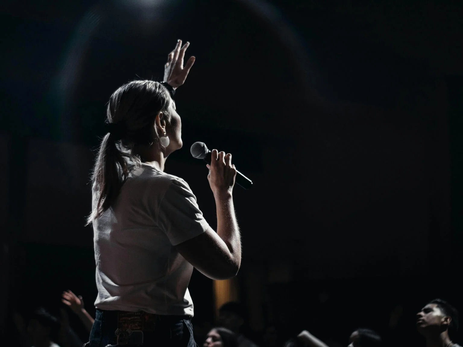 Singer seen from behind on a wedding stage, hand on in-ear monitor, counting the beat before the backing track starts