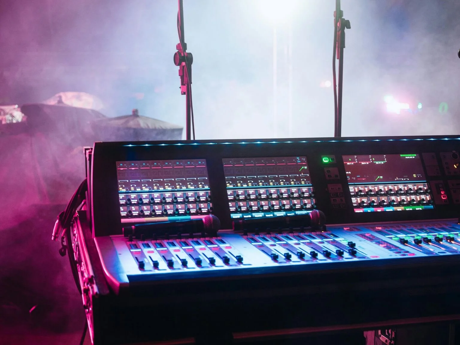 Mixing console faders aligned at equal height during soundcheck, symbolizing matched volume across a setlist